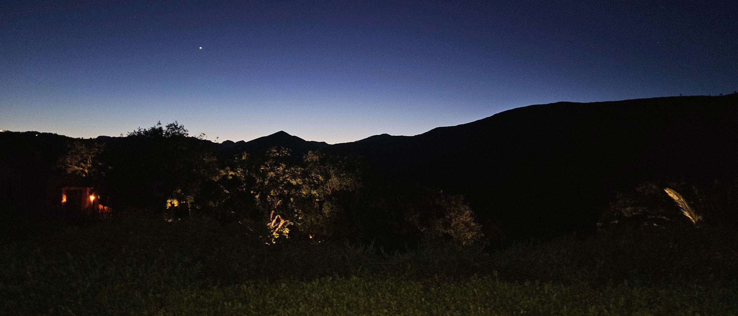 The dark ridge of Pyramid Mountain against a deep blue sky just after sunset, a single star above.